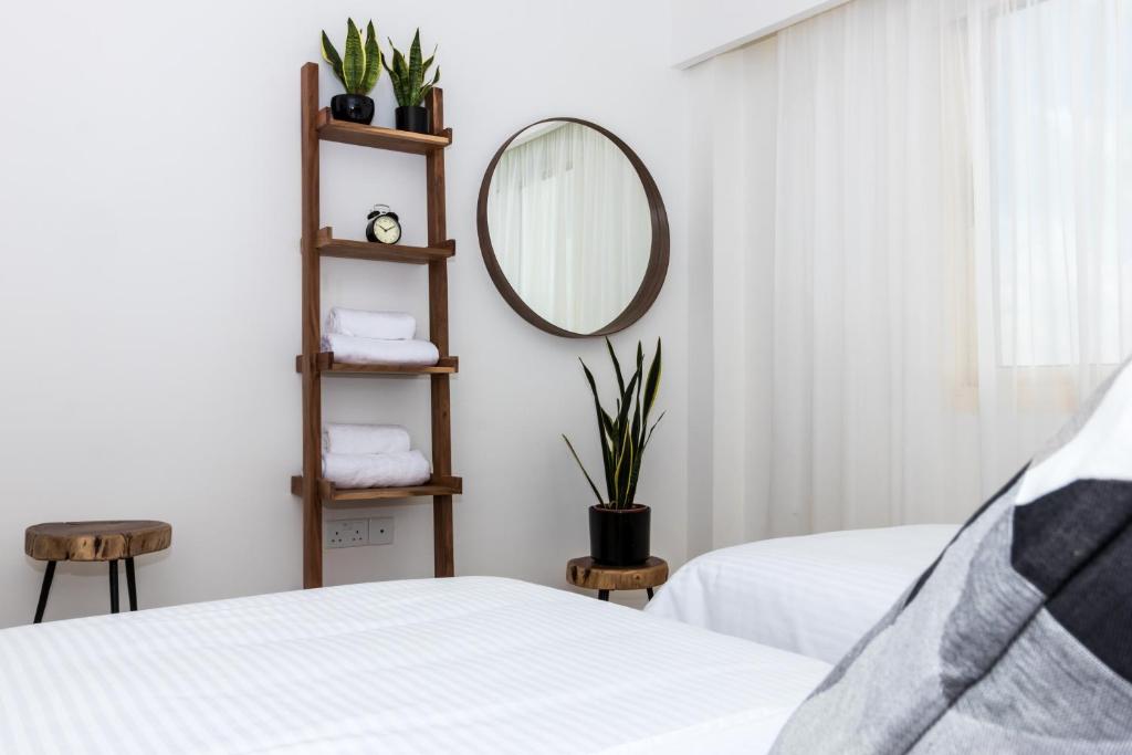 a bedroom with two beds and a mirror at Elysia Park in Paphos