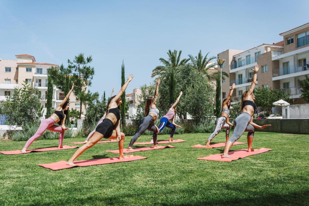 a group of people doing yoga in the grass at Elysia Park in Paphos
