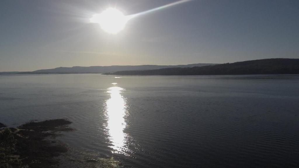 a view of a large body of water with the sun at Casa MAREIRA - VACACIONES en el mar in Vilagarcia de Arousa