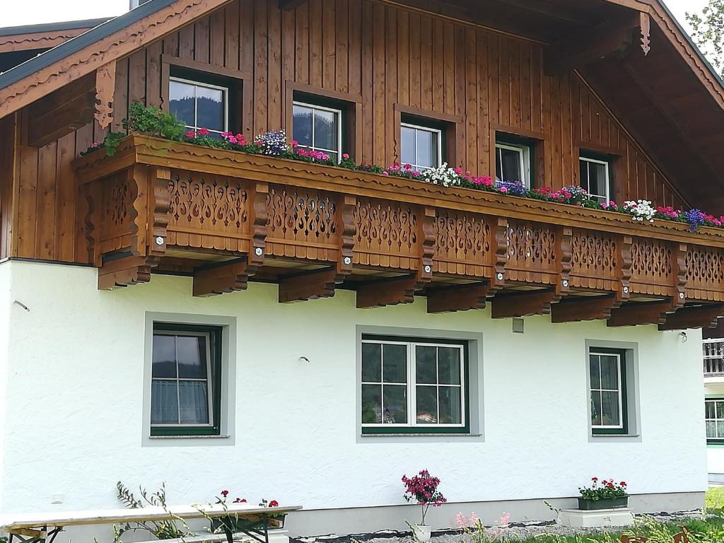 einen Holzbalkon an der Seite eines Hauses mit Blumen in der Unterkunft Haus Heimatblick in Abersee