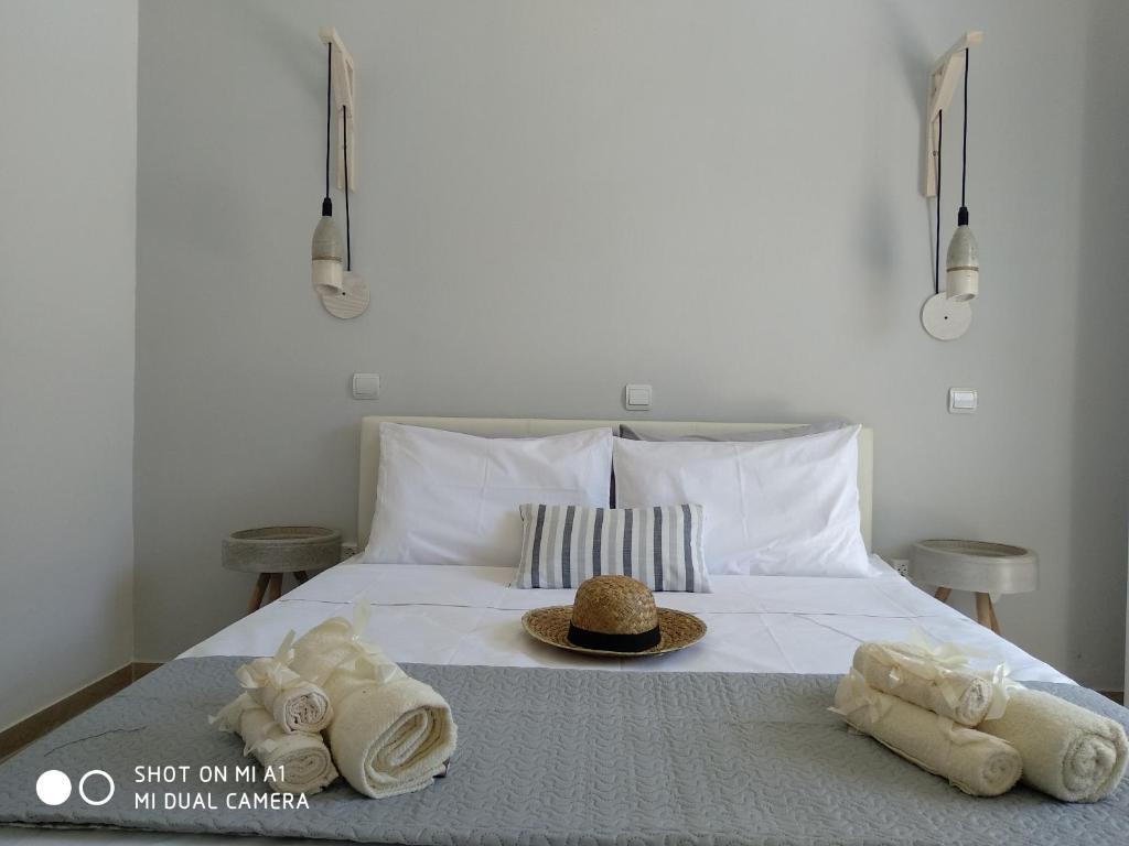 a bed with towels and a hat on it at Paleokastritsa Studios - Sun's Gift Spiros in Paleokastritsa
