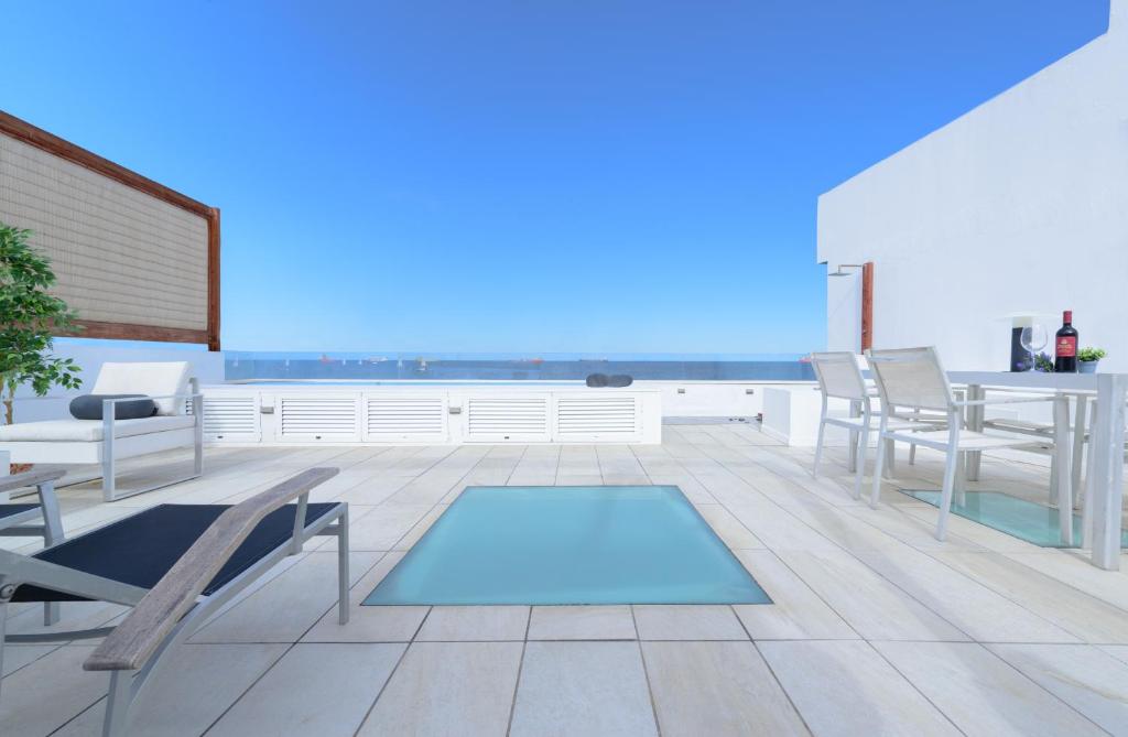 un patio avec des chaises et une piscine sur le toit dans l'établissement Villa Marina, Sol y Sal, à Las Palmas de Gran Canaria