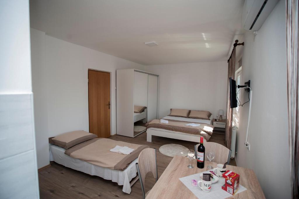 Habitación pequeña con 2 camas y mesa. en Guesthouse Buco en Trebinje