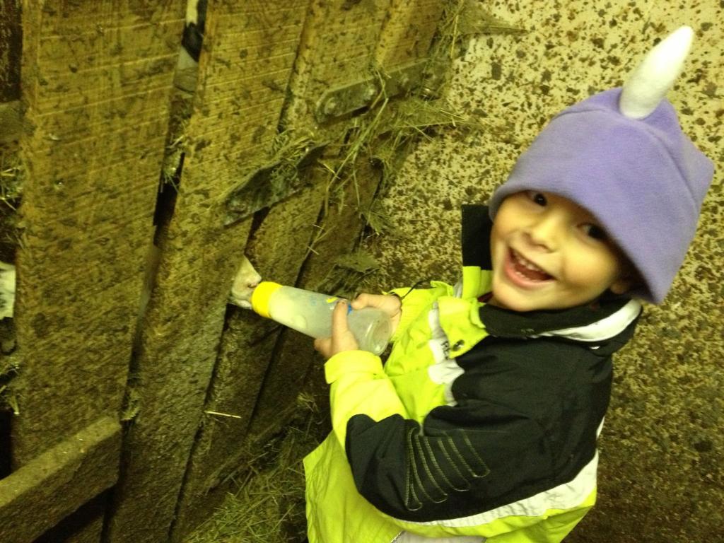 a young child wearing a hat holding a baseball bat at Agriturismo Maso Larciunei in Selva di Val Gardena