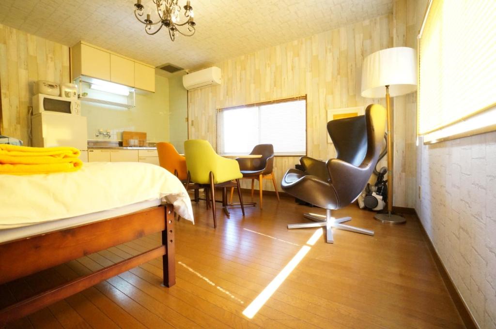 a bedroom with a bed and chairs and a kitchen at Takayama - Apartment / Vacation STAY 34382 in Takayama
