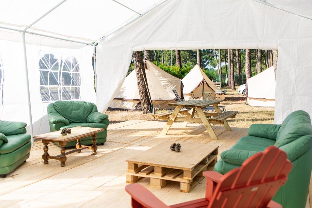 een tent met twee banken en een tafel en stoelen bij The Spot Surfcamp in Biscarrosse