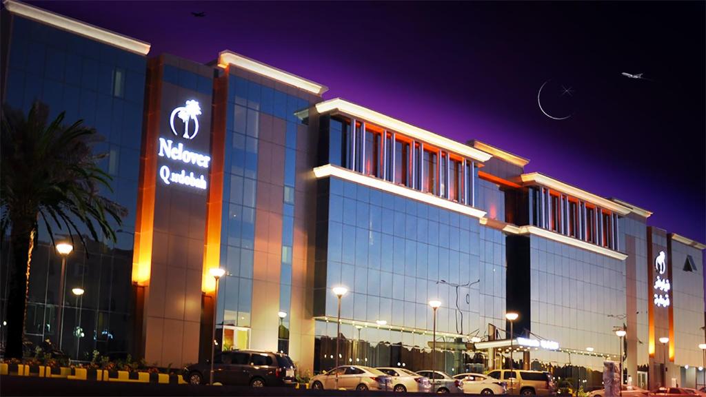 a large building with cars parked in front of it at Nelover Qurtubah Hotel in Riyadh