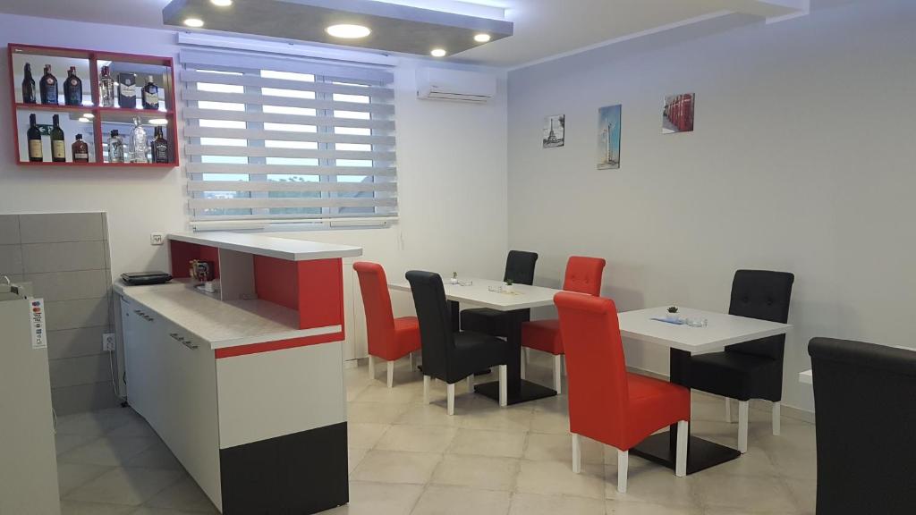 a restaurant with two tables and red chairs at Airport view Apartment in Belgrade