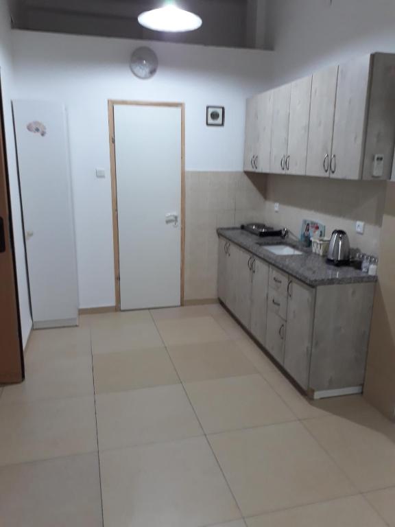 una cucina con armadi bianchi e piano di lavoro di Guest House Orlihome a Haifa