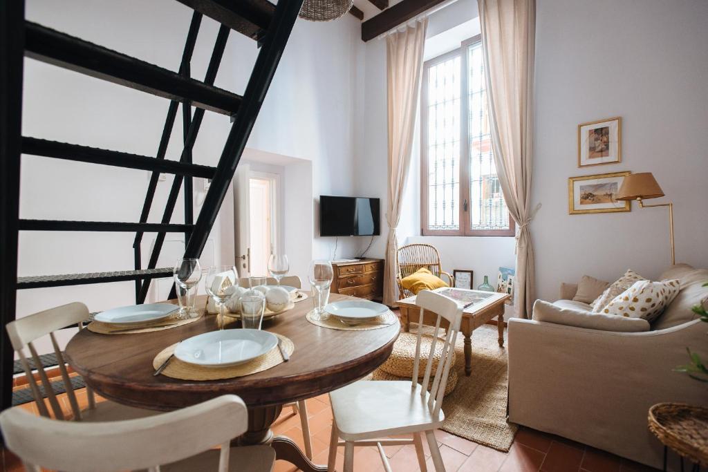 un soggiorno con tavolo, sedie e divano di Casa Galera Historic Downtown Apartment in Seville a Siviglia