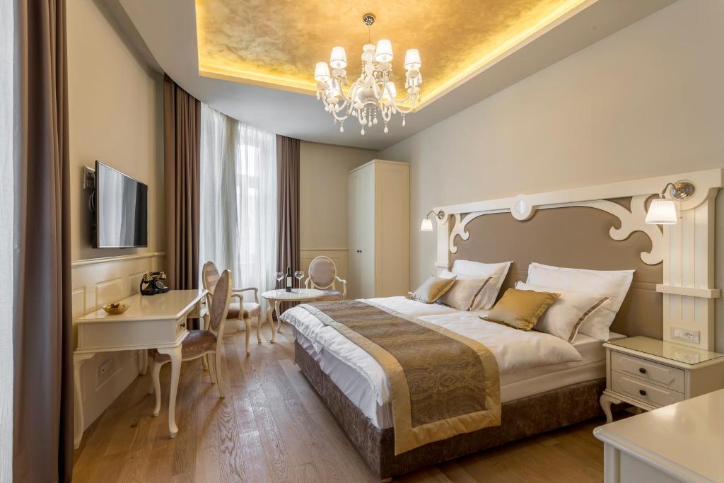 a hotel room with a bed and a desk and a dining room at Royal Piazza in Split