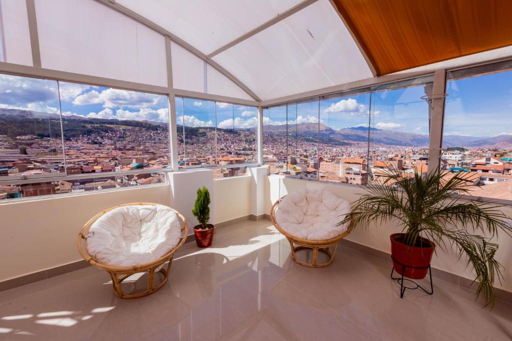 a room with two chairs and a view of a city at Cozy Room Cusco in Cusco