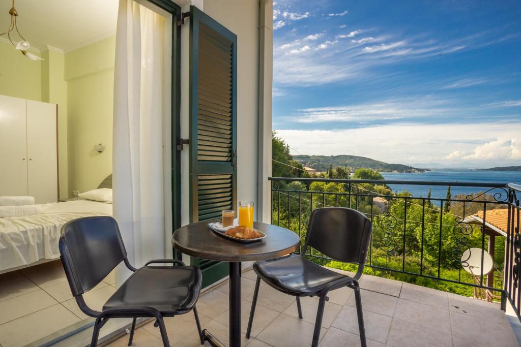 a room with a balcony with a table and chairs at Ionian Melody in Nikiana