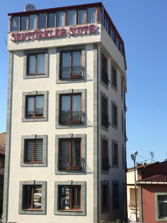 Ein weißes Gebäude mit einem Schild, auf dem die Suite SEymker steht in der Unterkunft Senturkler Suite in Trabzon