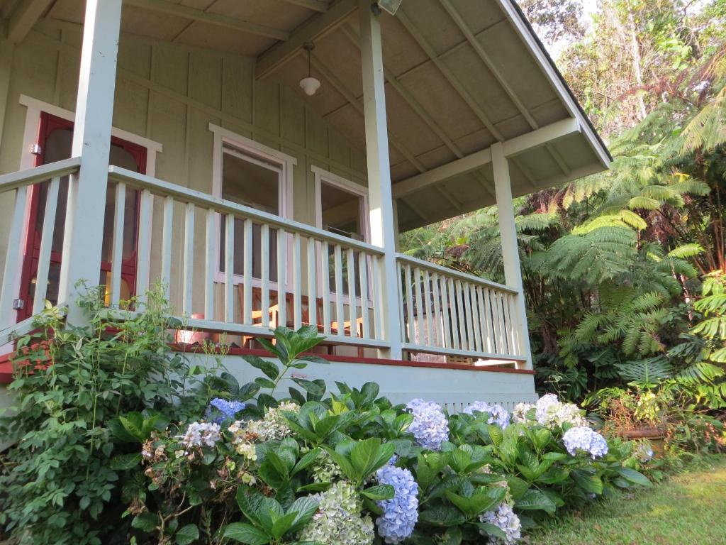 a front porch of a house with flowers at Carson's Kaloko Mountain Cottage in Kailua-Kona