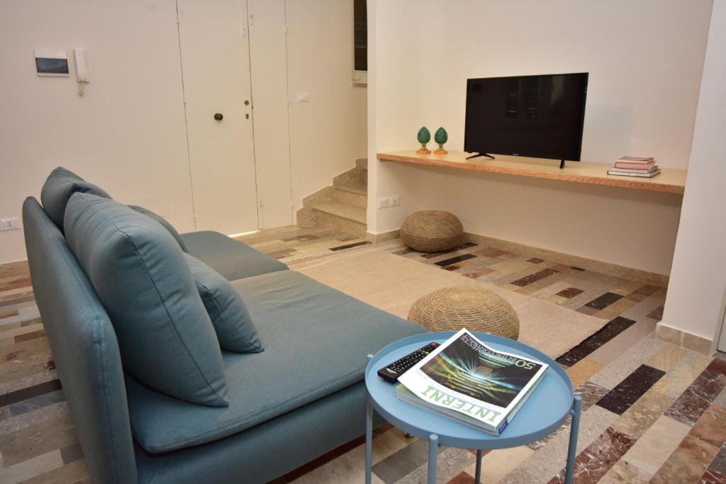 uma sala de estar com um sofá azul e uma mesa em Casa Tresca - Holiday Accommodations em Menfi