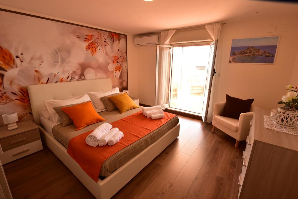 1 dormitorio con 1 cama grande y toallas. en La Petite Maison, en Aci Castello