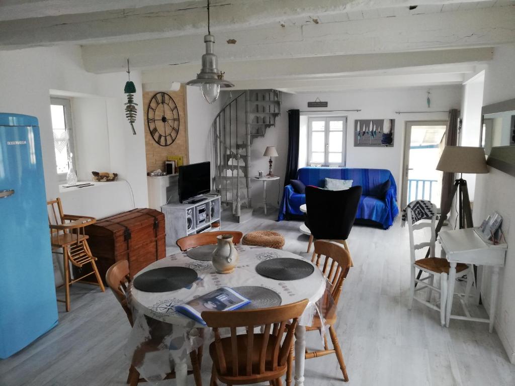 uma cozinha e sala de estar com mesa e cadeiras em MAISON DE CHARME AU CŒUR D AURAY em Auray