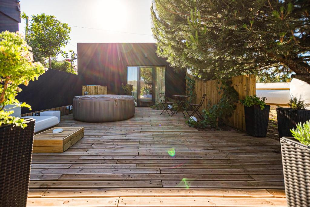 a backyard with a wooden deck with a hot tub at Privat Atelier in Setúbal