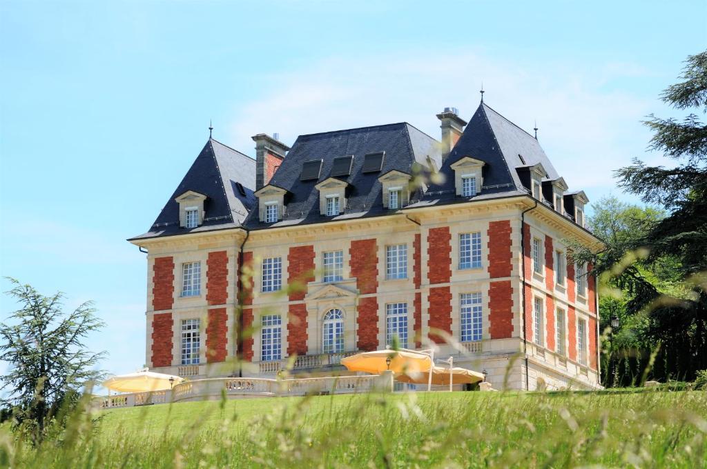 a large brick building with a black roof at Domaine de Mont-Renaud in Boncourt