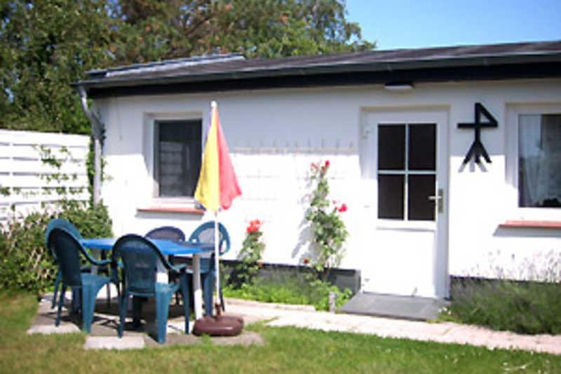 einen Tisch und Stühle vor einem Haus in der Unterkunft Ferienhaus in Plogshagenauf Hiddensee in Neuendorf