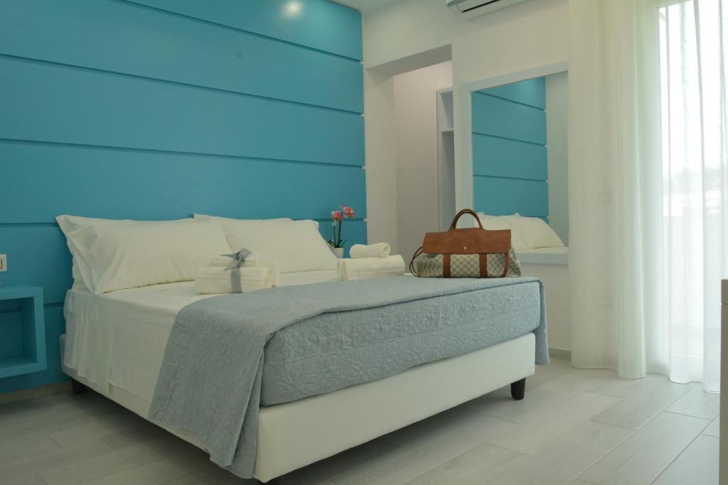 Schlafzimmer mit einem großen Bett mit blauem Kopfteil in der Unterkunft Dreams Tropea Mare "Parking Private" in Tropea