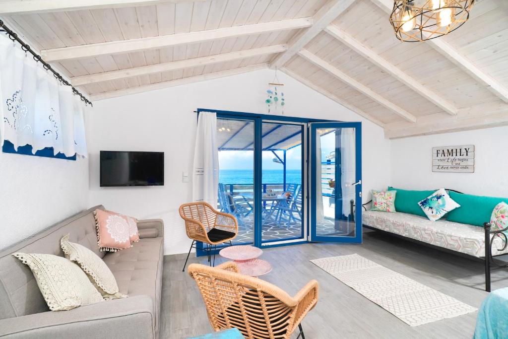 a living room with a couch and a table at GLAROS BUNGALOW in Skala Kallirachis