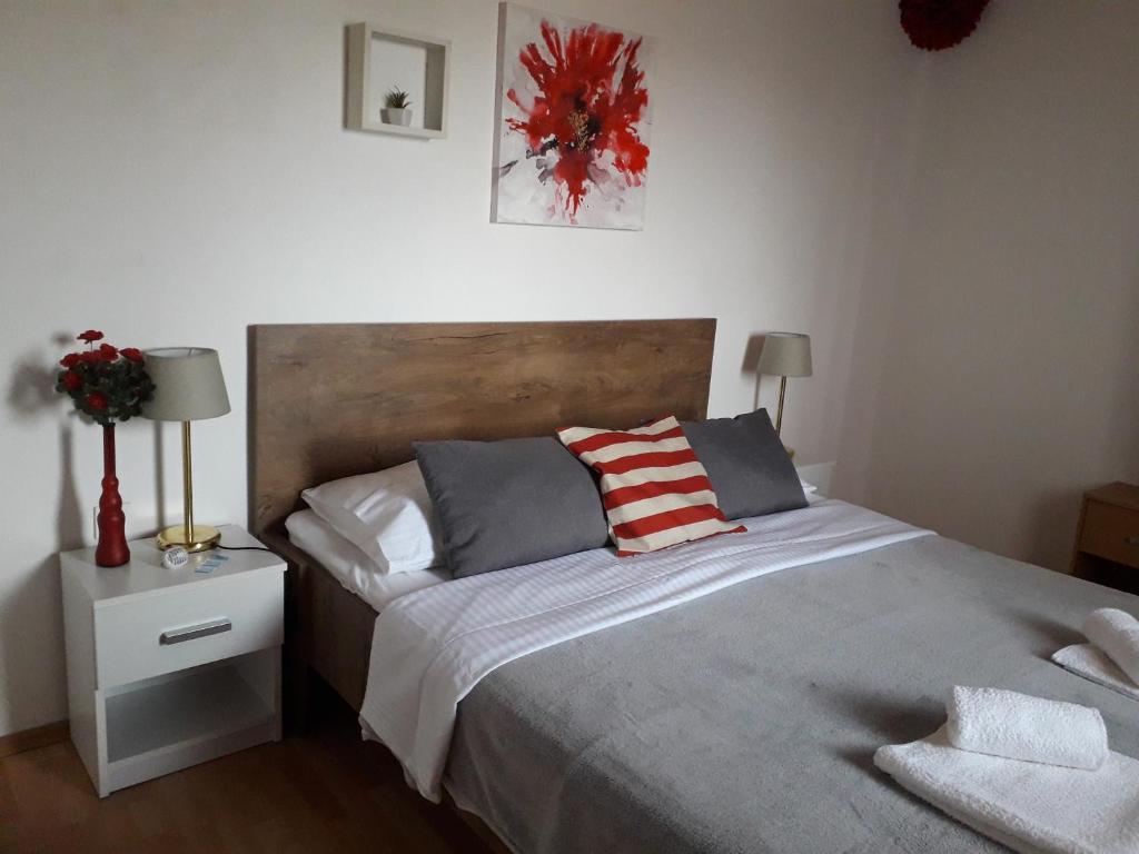 a bedroom with a large bed with two pillows at Apartman "Rosa" in Vodice