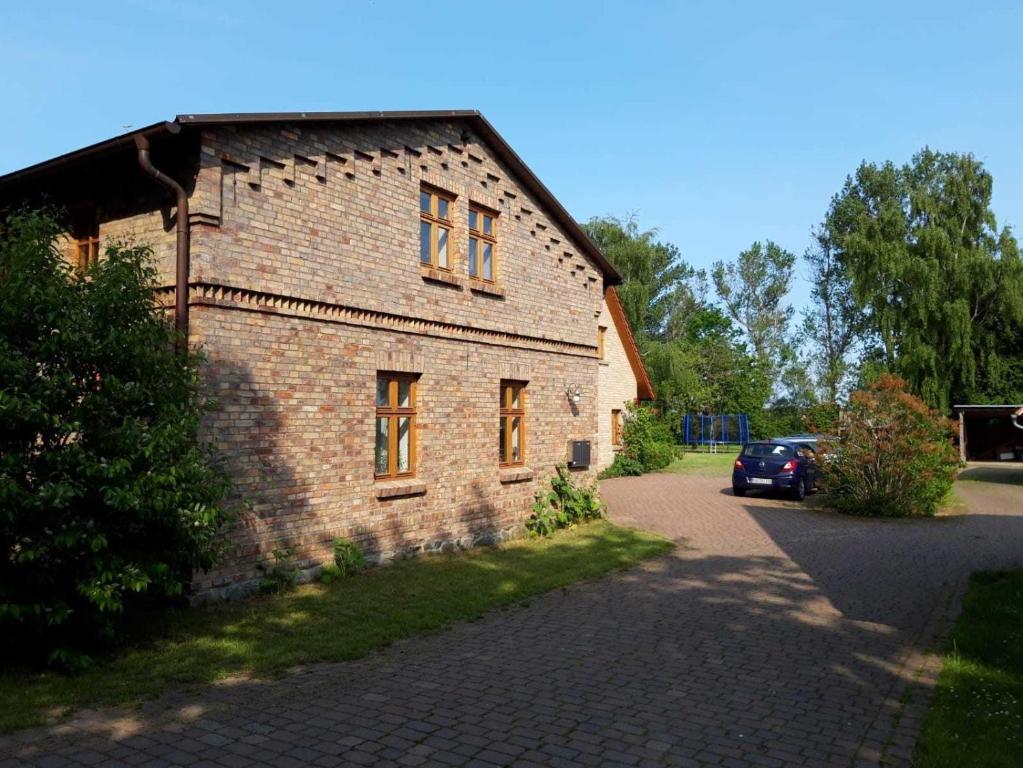 a brick building with a car parked in front of it at Ruegen_Fewo 220 in Poseritz