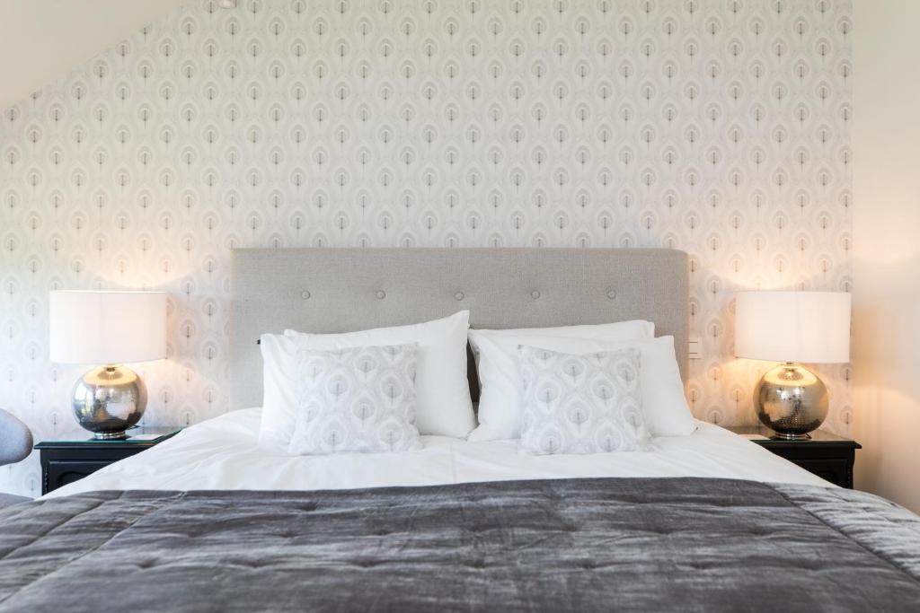 una camera da letto con un grande letto bianco con due lampade di Chez Spoons B&B a Bossut-Gottechain