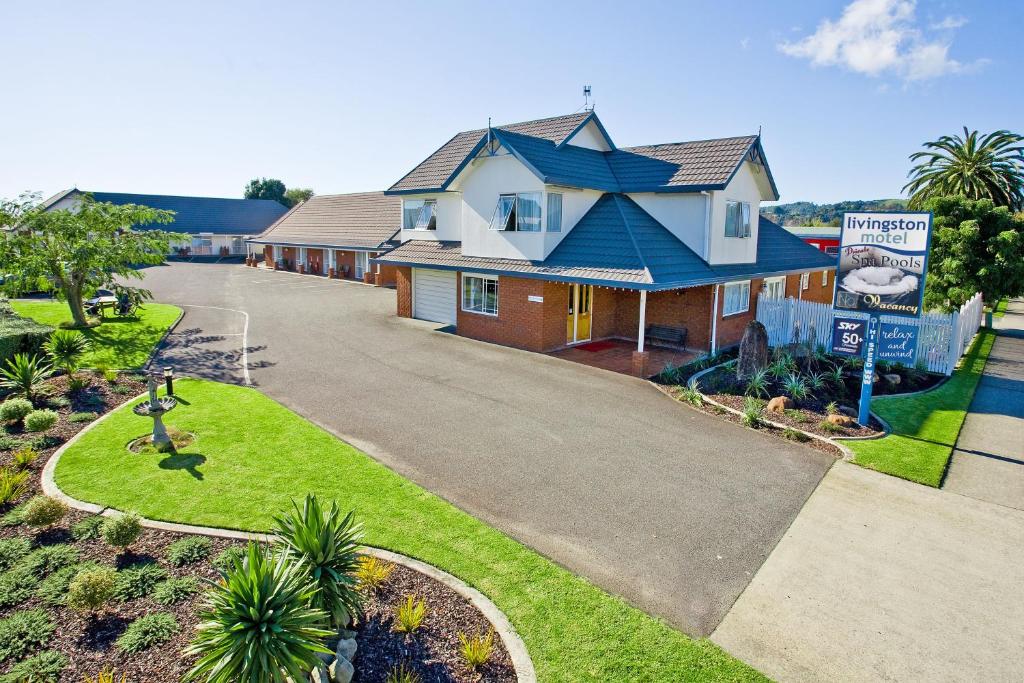 a house with a blue roof and a driveway at Livingston Motel in Whakatane