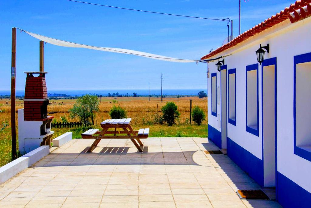 a picnic table on a patio next to a house at Monte Costa LuZ in Porto Covo