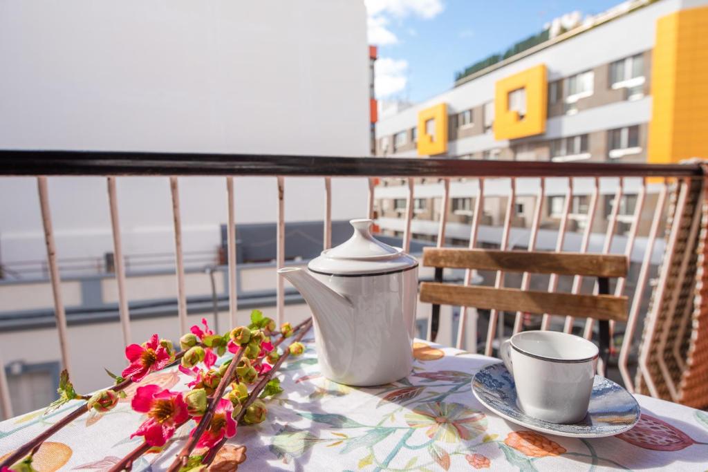 una mesa con tetera y flores en el balcón en Sta Cruz centro con balcón, WiFi super rápida y zona para trabajar en remoto, cerca intercambiador, en Santa Cruz de Tenerife
