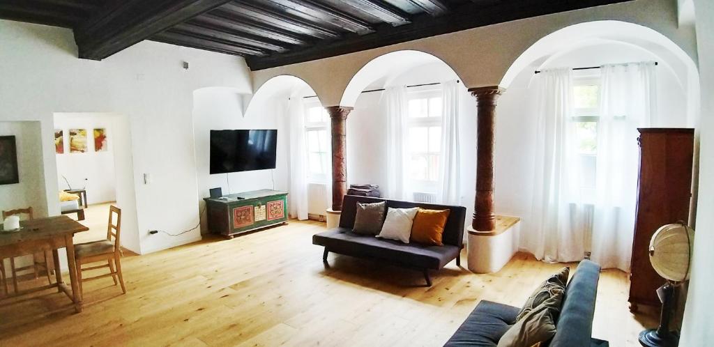 - un salon avec des arches, un canapé et une télévision dans l'établissement Renaissance Apartment Marktplatz, à Gmunden