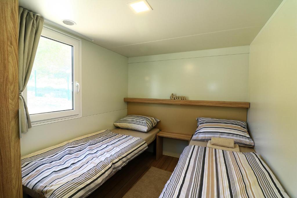 Postel nebo postele na pokoji v ubytování MOBIL HOMES MALUFI 266