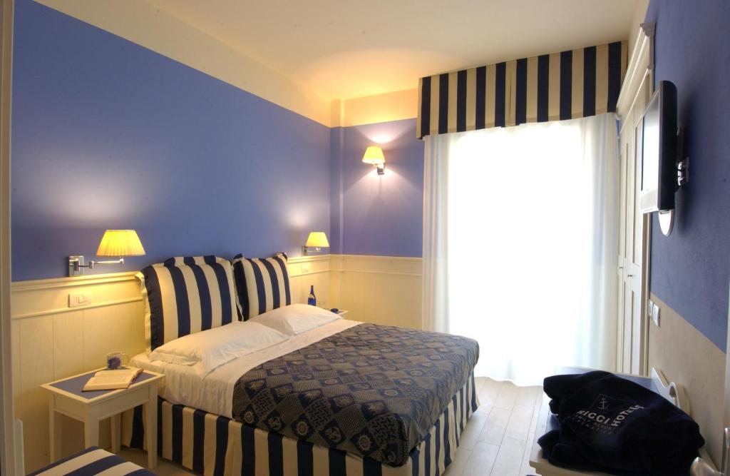 a hotel room with a bed and a chair at Hotel Sport & Residenza in Cesenatico