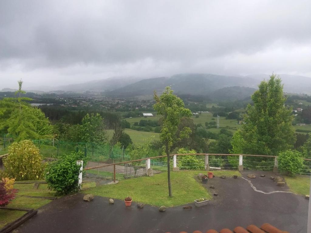 uma vista para um parque de estacionamento com uma árvore em En la colina 2 Montañealde em Gamiz-Fika