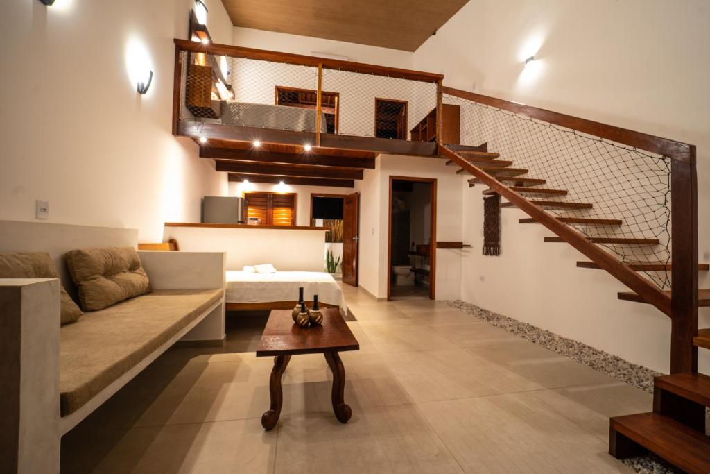 a living room with a couch and a staircase at Vila Loop in São Miguel do Gostoso