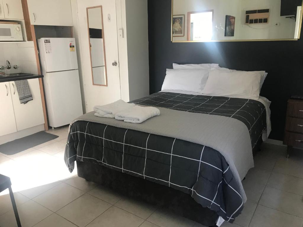 a bedroom with a bed with two towels on it at Dover Motel in Moree