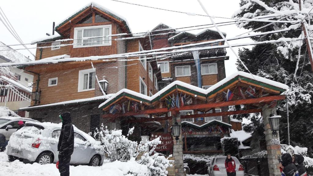 a snow covered building with a snowboard in front of it at Ruca Cheli Village Ski Hotel in San Carlos de Bariloche