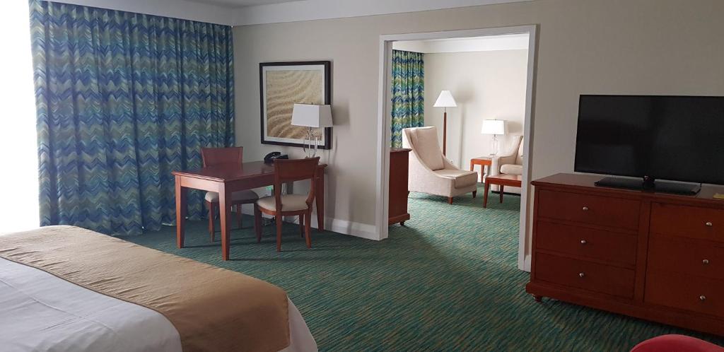 a hotel room with a bed and a desk and a television at Lighthouse Pointe at Grand Lucayan Resort in Freeport