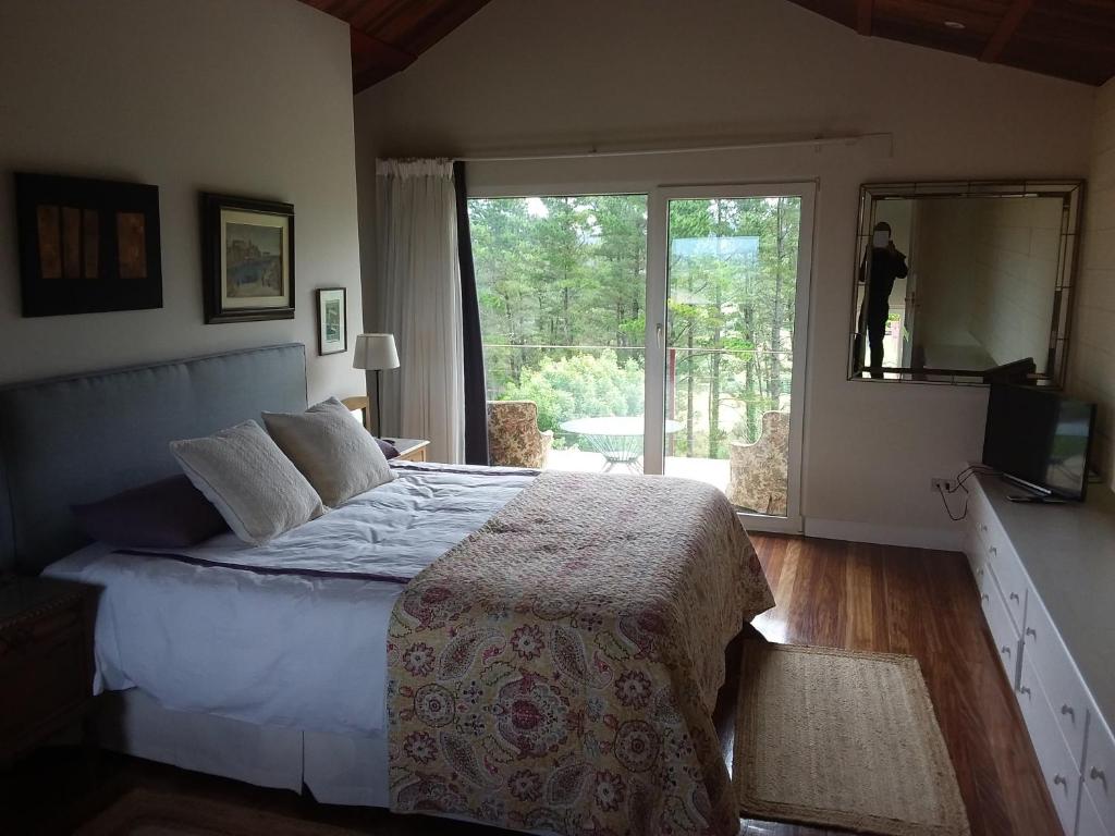 un dormitorio con una cama y una ventana grande en En la colina 2 Montañealde, en Gamiz-Fika