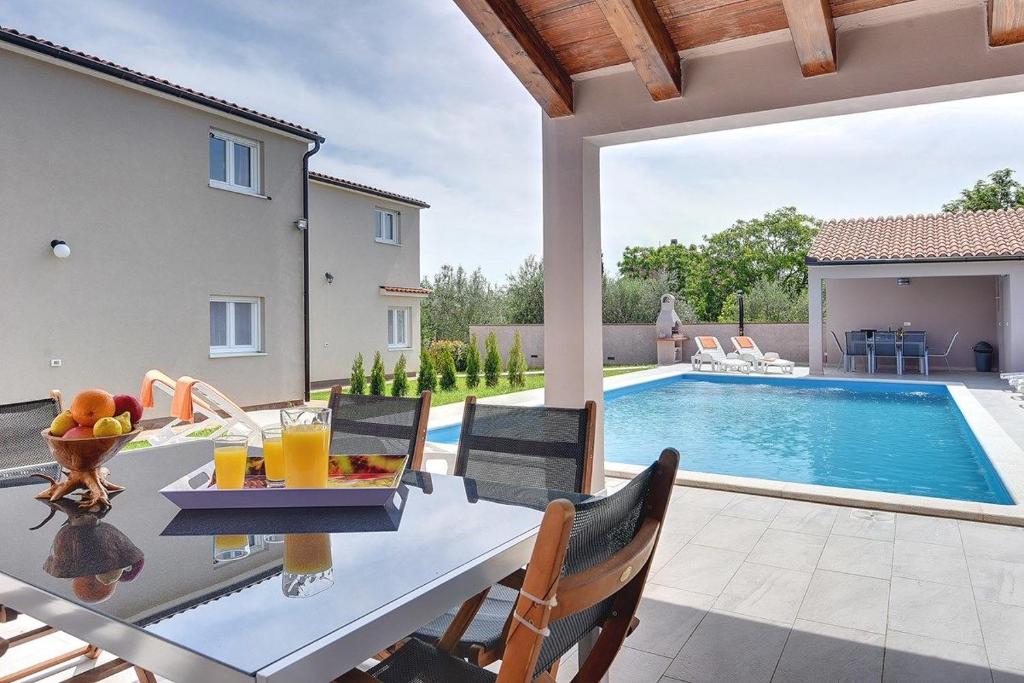 une terrasse avec une table et des chaises ainsi qu'une piscine dans l'établissement Villa Marcelia, à Pula