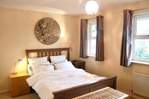 a bedroom with a large bed and two windows at luxury two bedroom apartment in Thornton heath in Thornton Heath