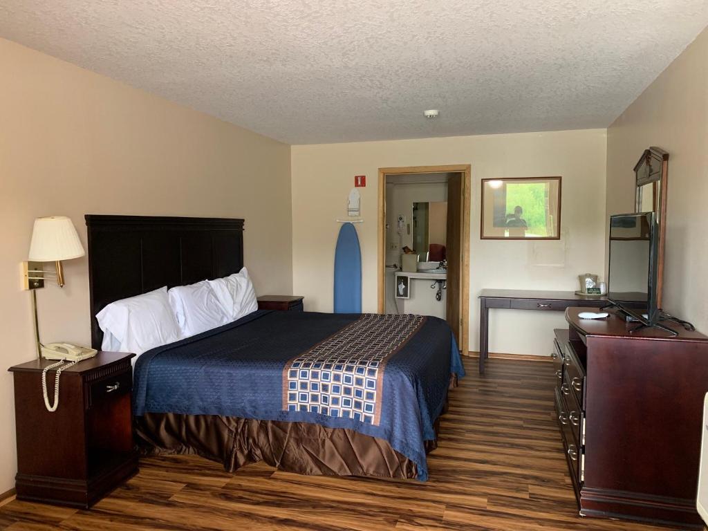 a hotel room with a bed and a television at Riverwood Inn in Glenwood