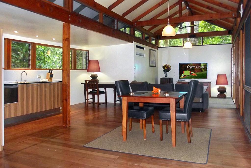 a dining room and living room with a table and chairs at Crystal Creek Rainforest Retreat in Crystal Creek