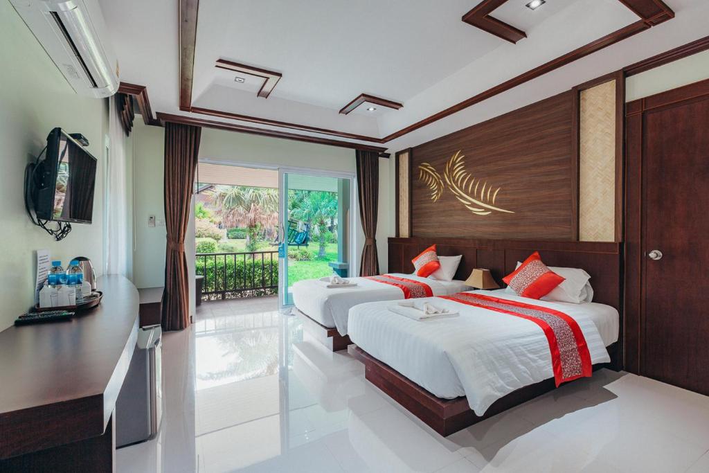 a bedroom with two beds and a large window at Palm Kiri Aonang Resort in Ao Nang Beach