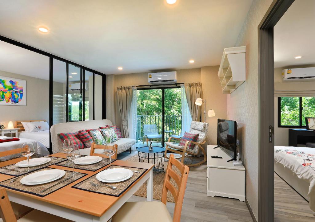 NaiYang beach Title Residencies by My Home Phuket في شاطئ ناي يانغ: غرفة معيشة مع طاولة طعام وغرفة معيشة
