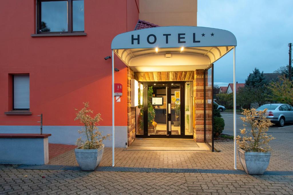 a hotel entrance with a sign that reads hotel at Hôtel Le Verger De Bischwiller in Bischwiller