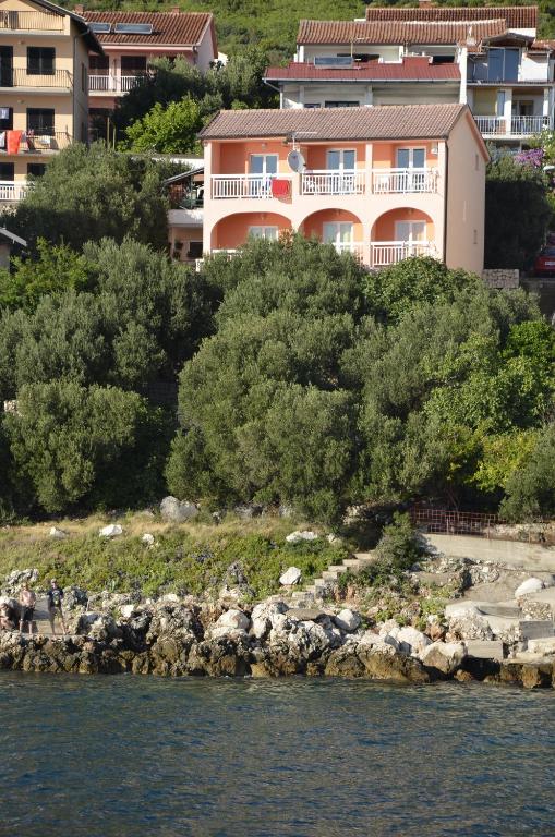 a building on a hill next to the water at Villa nad Morem in Podaca